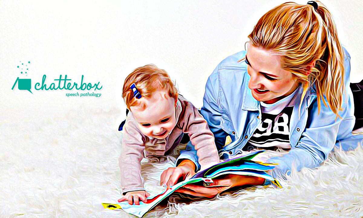 mum teaches baby how to read on the rug